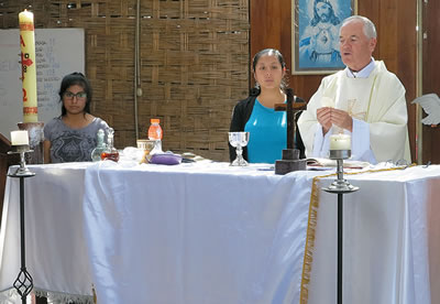 Isabel in her chapel as Eucharistic minister with Fr. John Boles