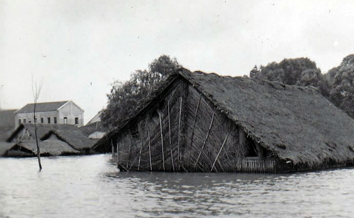 Flooding covers all but the roof of a mat house